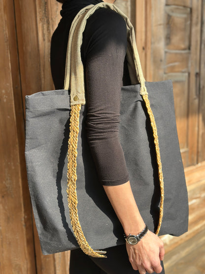 Moskana Black tote bag with straw handles for carrying a hat