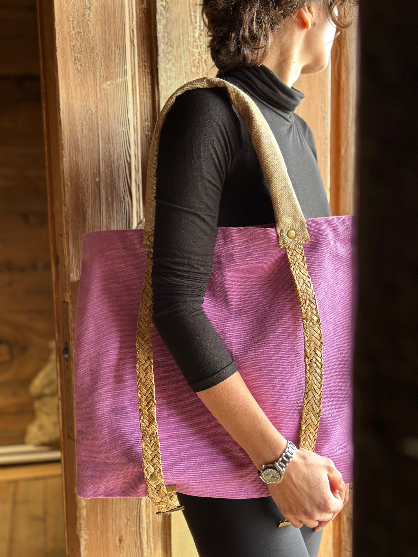 Purple tote bag with straw handles for carrying a hat