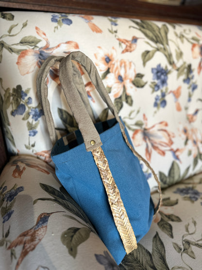 Moskana Blue tote bag with straw handles for carrying a hat